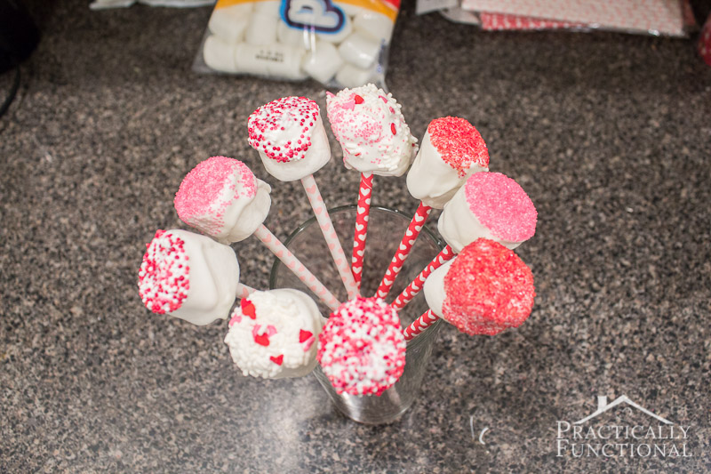 Candy Covered Valentines Marshmallow Pops set the marshmallow pops in a tall glass to dry
